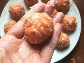 手上沾少许清水抓起少许胡萝卜肉末双手交换团成丸子。