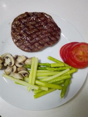 取一块牛排，放入已烧热的锅中，2面煎至8分熟，准备少许的素菜提前焯水