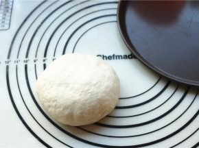 发酵完成的面团排出气体，再次揉圆，准备好披萨盘。