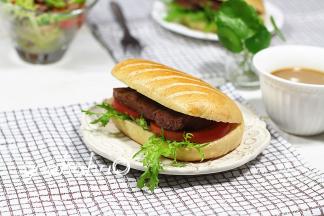 加入西红柿片、苦菊，牛排切掉边角，切成2片，加入面包中，把面包放入牛排锅中，稍微煎一下压上痕迹，开吃吧