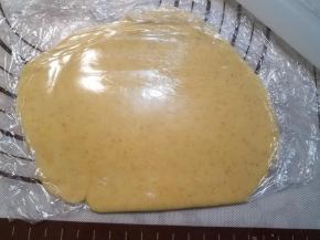 取出80g一块的面团，上下垫上保鲜膜，用擀面杖尽量擀成薄薄的圆片。