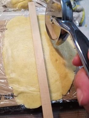 取出一块面团也用之前的方法擀成薄片，用滚刀切成条状。