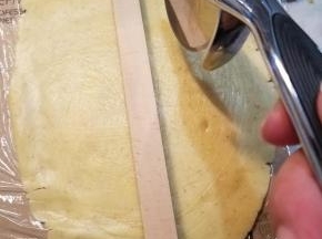 取出一块面团也用之前的方法擀成薄片，用滚刀切成条状。