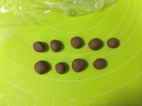 把可可面团分为9小份，其中3份做熊猫的耳朵，6份做眼袋和鼻子