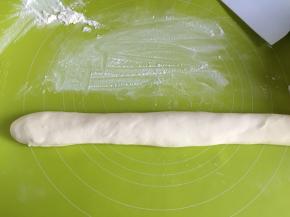 20分钟以后取出面团，面板上撒适量面粉防粘，把面团揉成长条