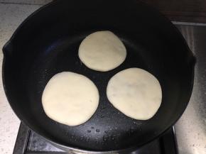 不粘平底锅内抹一层食用油，放入生饼胚，先小火煎一面