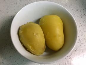 把土豆放凉水冲一下，剥去皮。
