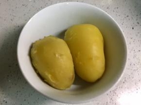 把土豆放凉水冲一下，剥去皮。