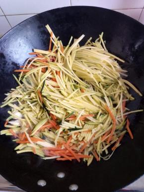 放入南瓜丝和胡萝卜丝翻炒