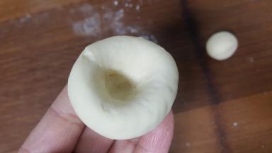 9．取大的面团，中间捏出一个凹坑。