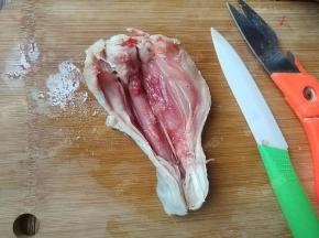 借助剪刀和锋利的小刀，在鸡腿背部一刀剪到底