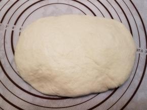 将发酵好的面团按扁，挤出气泡。