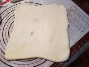 用擀面杖擀平，然后两边向内对折。