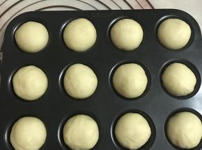 把发酵好面团进行排气，分成17~18克的小面团，大约可分成28个。
滚圆放入模具中。