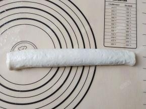 将面团从一头向另一头卷起来。注意卷紧