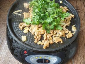 接着关火并加入香菜。继续翻炒均匀，余温会使香菜变熟。将烤肉盛盘。