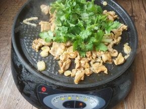 接着关火并加入香菜。继续翻炒均匀，余温会使香菜变熟。将烤肉盛盘。