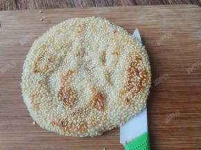 在烧饼上横切一刀将烧饼切开（但不要切断）