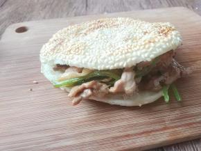 将烤肉填入烧饼里夹着吃