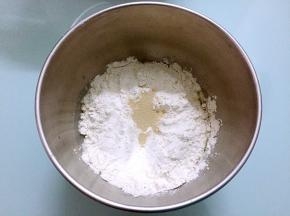 把主材料除了黄油外，都放入和面桶，顺序为牛奶、鸡蛋液、糖和盐对角放，然后放面粉，酵母放最上面，