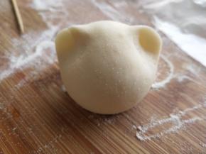 取一份揉成光滑的馒头，然后在面团上方两边耳朵位置前后捏一下捏出两个小耳朵