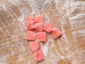 取一份面团切一块加少许红曲粉（没有的话可以用蔬菜汁做彩色面团，或者直接加一点点食用色素也可以），揉匀并擀扁，切成长1.5cm宽1cm的面片，用筷子从中间夹成蝴蝶结的形状