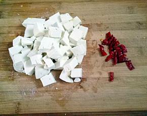 再把豆腐切成小丁，干辣椒切成小段。