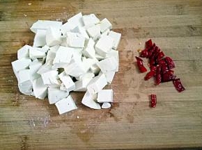 再把豆腐切成小丁，干辣椒切成小段。