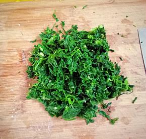 在取一把荠菜把水分挤干，随便切一下，