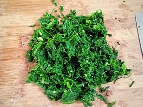 在取一把荠菜把水分挤干，随便切一下，