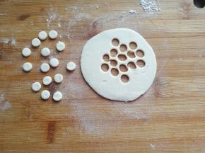 面团静置期间，我们来做小鸟的眼睛和嘴巴：白色小面团擀开，用小号圆形裱花嘴刻出白色小圆形；