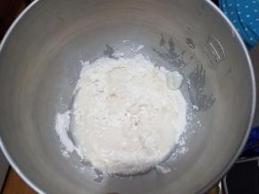 把油皮中的所有粉类倒入搅拌碗里，把混合好的猪油和冷水加进去，这次我们用的是厨师机揉面，手揉也是一样的，我们要揉出弹性，就是面团光滑变结实了。