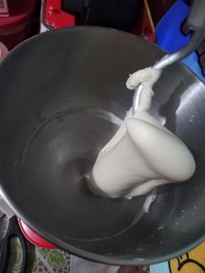 好的面团，它会挂在厨师机的钩子上，不会掉落的，我们用手撑开，可以看见面筋，但还没有连成一片，并没有形成大片的薄膜，所以我需要静止，让薄膜连起来，用保鲜膜把油皮包起来密封静置30分钟松弛。