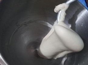 好的面团，它会挂在厨师机的钩子上，不会掉落的，我们用手撑开，可以看见面筋，但还没有连成一片，并没有形成大片的薄膜，所以我需要静止，让薄膜连起来，用保鲜膜把油皮包起来密封静置30分钟松弛。