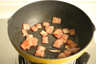 炒锅放油，下入培根煎香，盛出待用。