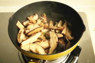 下入香菇片炒软。
