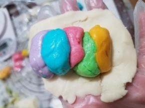 水油皮擀成长片，颜色可按自己的喜好排列整齐。想要哪头作为圆心，在摆放油酥时将红色放在两头的任意一头。