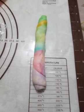 从油酥分布均匀的一头轻轻卷起，切口朝下，醒发10-15分钟，一定要用保鲜膜盖好，上面用潮毛巾盖在保鲜膜上，毛巾不要太湿，避免保鲜膜边缘透风，导致油酥皮变干或变硬。