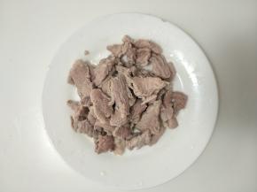 猪肉下开水锅煮熟后切成小片。
