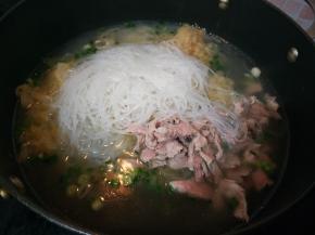 加入高汤、酸菜、肉片、粉丝和盐。