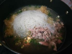 加入高汤、酸菜、肉片、粉丝和盐。