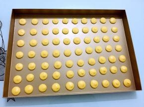 在烤盘上间隔的挤出圆形形状， 大小一致