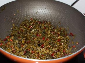 锅倒入油，把酸菜、红辣椒倒入锅中煸炒；