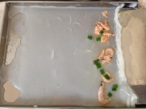 取出，用刮板将肠粉从有虾的一边刮起来，一直卷到另一边