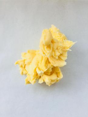 两种黄油充分软化后，加入低粉搅拌均匀。取一张油纸，将混合好的黄油放到上面。