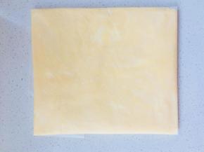 折叠油纸边缘，将黄油压成一个黄油片。放入冰箱冷藏30分钟，或者冷冻15分钟。