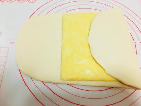 取出主面团，擀成长方形，大小可以包裹住黄油片即可。黄油片的软硬程度要可以弯曲。