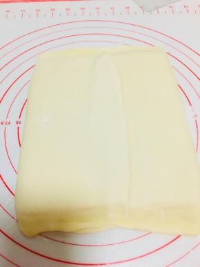 将黄油片包裹在面中，收口在中间。捏紧上下两端收口。压实中间接口。