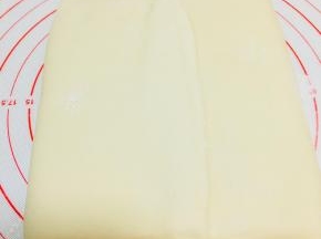 将黄油片包裹在面中，收口在中间。捏紧上下两端收口。压实中间接口。