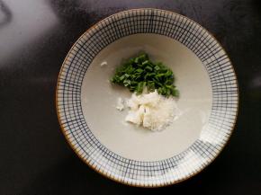 在等待水开的时候，制作料汁，在碗中放入猪油，蒜叶和白砂糖